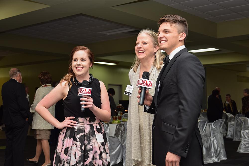 Christian Naylor, left, and Jesslyn McCandless, third from left, interview Dr. Donna Hedgepath, vice president for academic affairs, at the 9th Annual Derby Rose Gala at Campbellsville University. (Campbellsville University Photo by Joshua Williams)