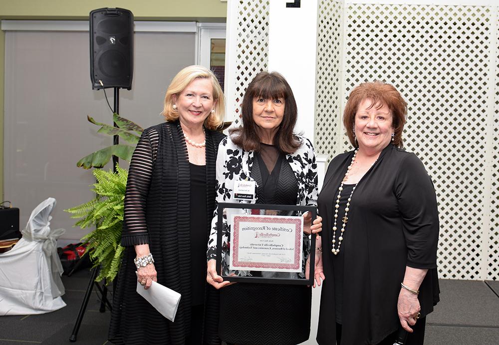 From left name, Sara Curry, chair of the Advancement Board, and Gwinn Hahn, chair of the Derby Rose Gala, third from left, give a Certificate of Recognition to Dr. Pat Cowherd, dean of the School of Business, Economics and Technology, who represented the School. (Campbellsville University Photo by Joshua Williams)