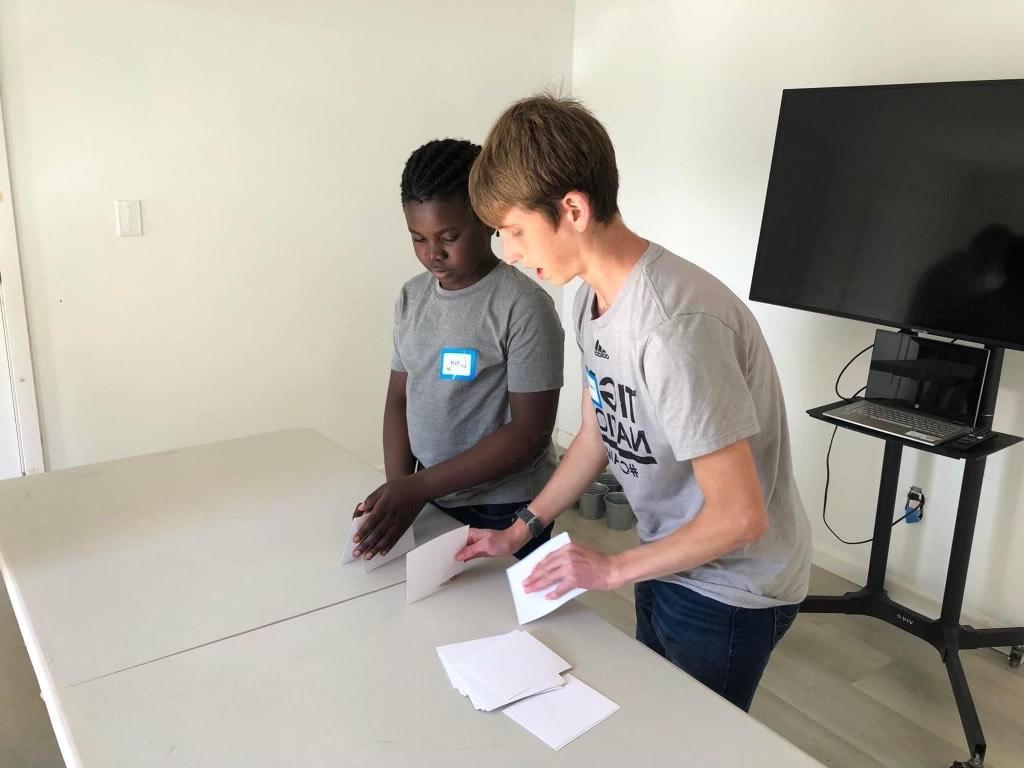 Two people standing at a table.